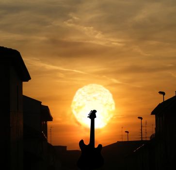 Sunset on the black silhouette of an electric guitar