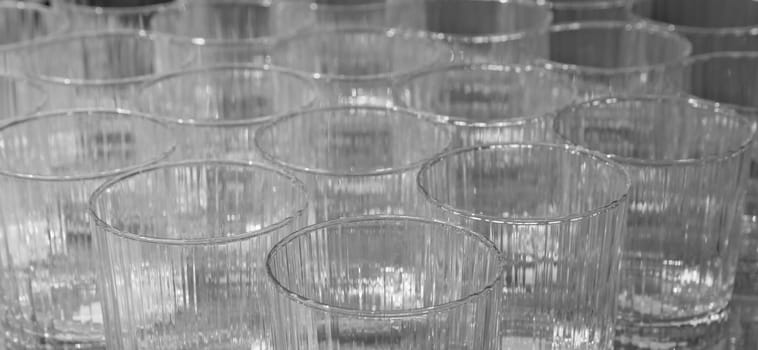 Rows of empty ribbed glasses with soft focus background