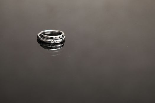 wedding rings on the glass table in black and white