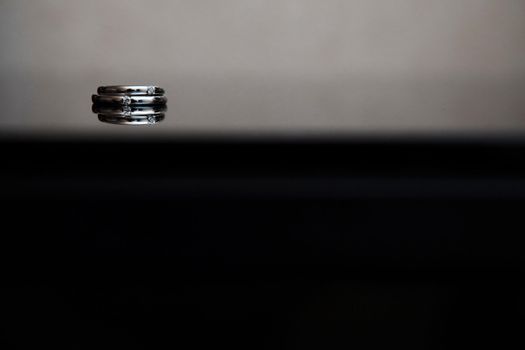 wedding rings on the glass table in black and white