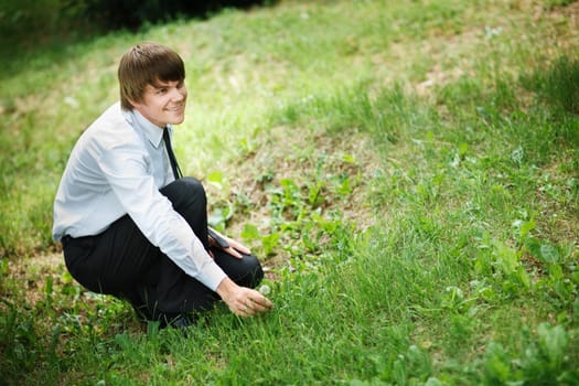 man ready to pick up a white dandelion