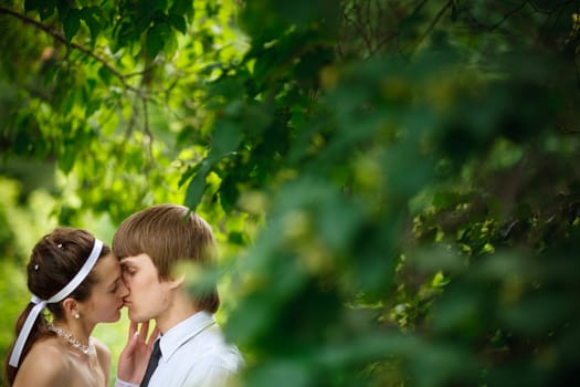 a bride and groom near the tree