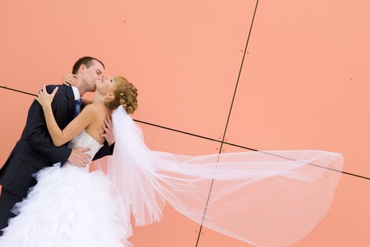 kiss of bride and groom near the wall 