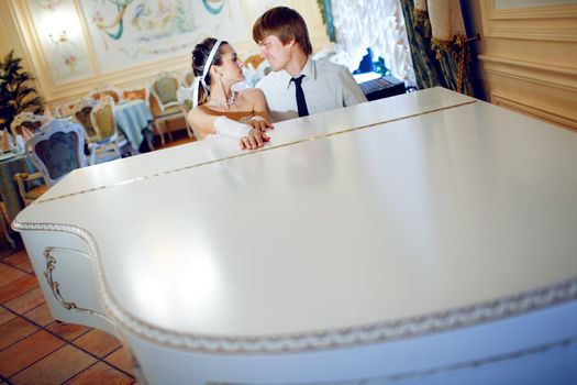 happy bride and groom at the piano