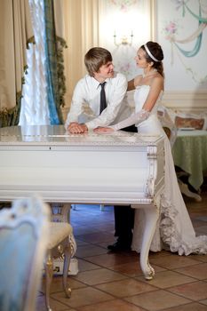happy bride and groom at the piano