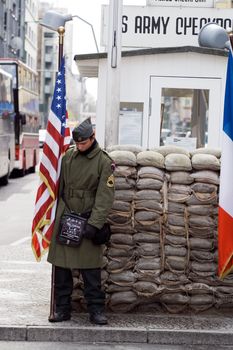 Soldier with American flag at Checkpoint Charlie. Berlin, Germany, april 14, 2008