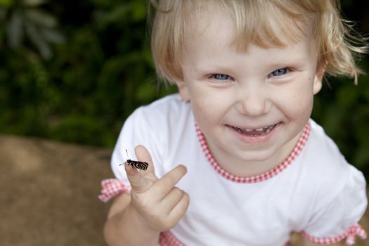 funny smiling girl with a butterfly on the finger

