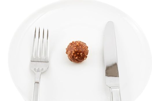 chocolate candy on a plate with knife and fork, shot on white