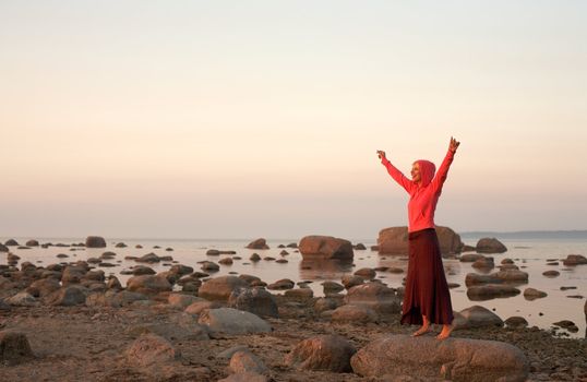 pretty blonde raising hands to the sun