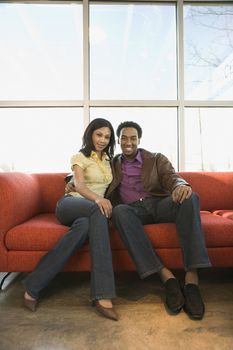 African American couple sitting on couch.