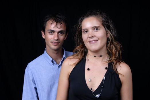 young couple together portrait on black background