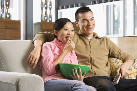 Asian couple watching television.