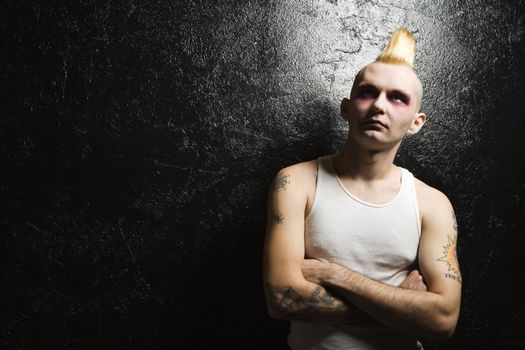 Portrait of mid-adult Caucasian male punk with crossed arms.