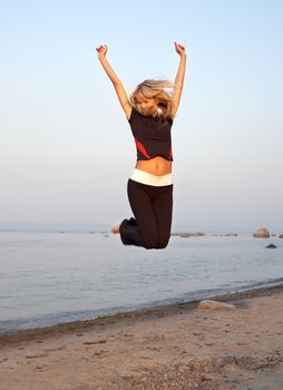 fit girl jumping at the seashore