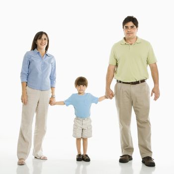 Hispanic family of three standing against white background holding hands.