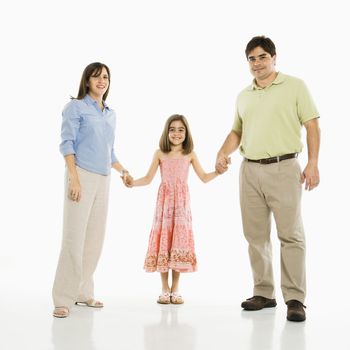 Hispanic parents and daughter holding hands standing against white background.