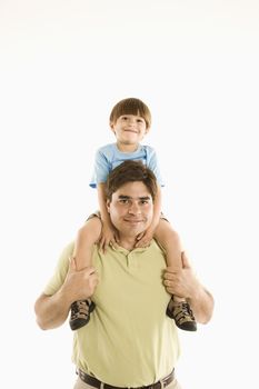 Father holding son on shoulders standing against white background.