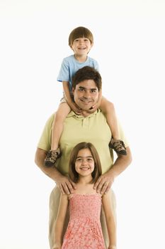 Father with son and daughter standing against white background.