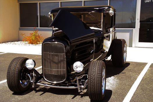 A classic black hotrod shines in the sunlight