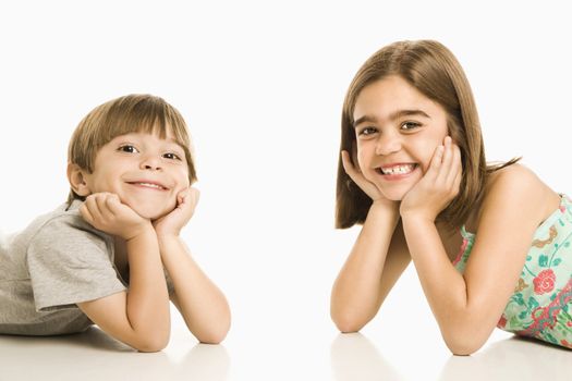 Portrait of girl and boy smiling against white background.