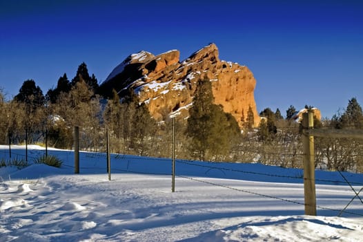 Red Rocks mark a stark contrast against the blue skies and snow of Colorado