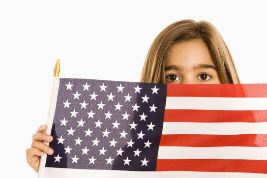 Girl peeking over American flag against white background.