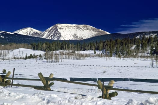 Colorado's Kenosha Pass in winter snowfall with snow capped Rocky Mountain Peaks