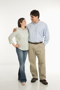 Full length portrait of couple standing smiling against white background.