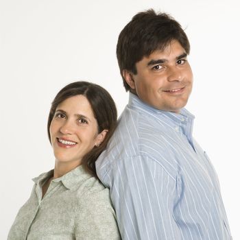 Portrait of couple standing smiling against white background.