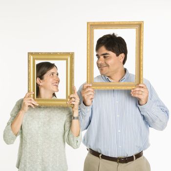 Man and woman looking through empty frames.