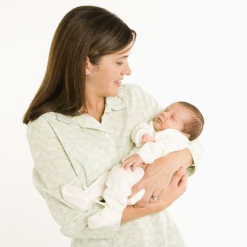 Mother holding baby smiling against white background.
