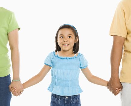 Asian girl holding hands with mother and father in front of white background.