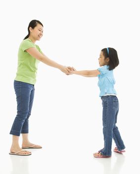 Asian mother and daughter playing together holding hands.