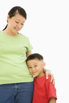 Asian mother standing with arm around son.