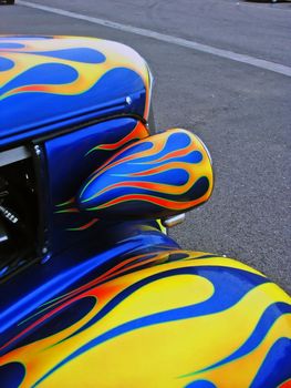 A blue American Hotrod car with yellow flames