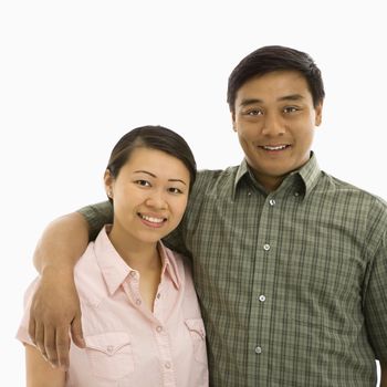 Mid adult Asian couple with arms around eachother smiling.