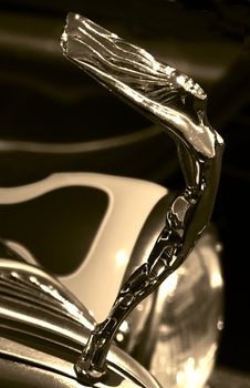 A elegant hood ornament on a hotrod in sepia