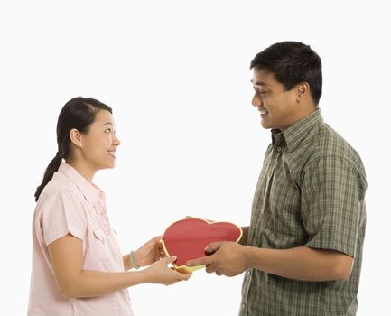 Asian man giving Asian woman a heart shaped box.