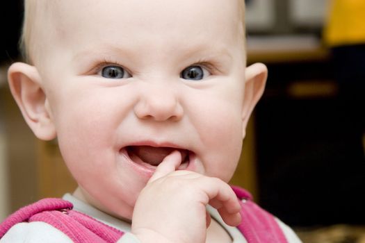 child with finger in the mouth finding teeth