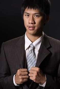 Closeup portrait of young business man of Asian on black background.