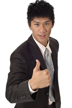 Young businessman holding thumbs up gesture on white background.