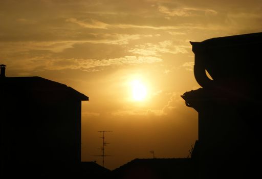 A great yellow sun rises on the rooftops of the city