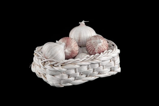 Some fresh garlic in the basket on black 