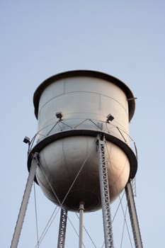 An old silver water tower lost in the blue sky
