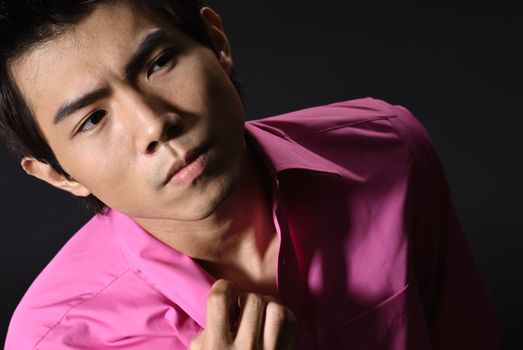 Portrait of modern young business man with confident expression on black ground.