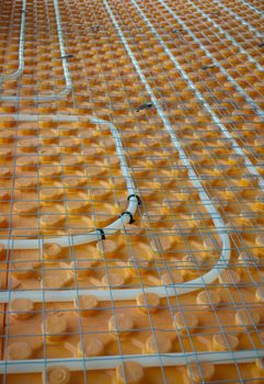 Orange posed Underfloor heating tube in a construction site