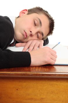 A tired, weary or bored student at desk sleeping or resting.