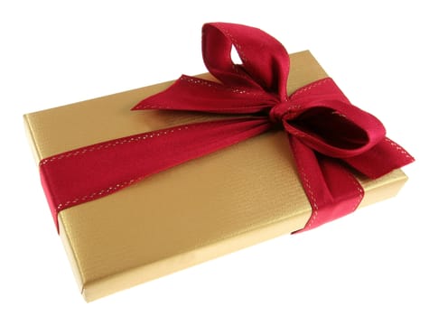A Christmas present wrapped in gold paper with red ribbon.
