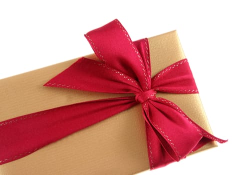 A Christmas present wrapped in gold paper with red ribbon.
