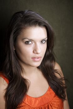 Pretty Hispanic woman in orange on green background